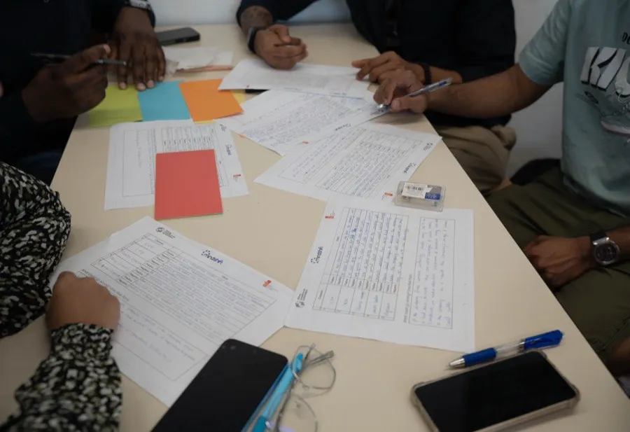 Des mains feuilletant des documents lors d’un travail collaboratif